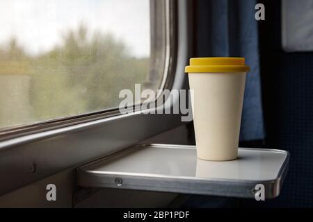 Una tazza di caffè di bambù con un coperchio di silicone giallo Foto Stock