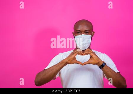 giovane uomo nero che indossa una maschera al naso e fa un segno d'amore Foto Stock