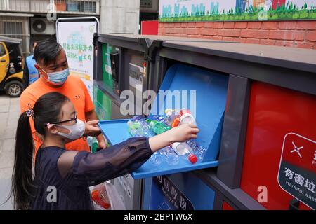 Pechino, Cina. 17 maggio 2020. Un bambino mette le bottiglie di plastica nel cestino intelligente della spazzatura di colore blu alla comunità residenziale di Shaojiu nel distretto di Dongcheng di Pechino, capitale della Cina, 17 maggio 2020. La comunità di Shaojiu ha avviato domenica un progetto di gestione dei rifiuti domestici. Varie misure, tra cui l'installazione di bidoni per rifiuti intelligenti e la fornitura di sacchi per rifiuti stampati tracciabili e diversi codici QR per le famiglie, sono state adottate per aiutare i residenti a impegnarsi meglio nella raccolta dei rifiuti. Credit: Xinhua/Alamy Live News Foto Stock