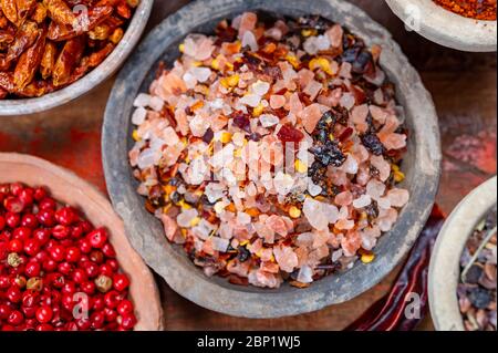 Raccolta di spezie indiane, sale di mare e roccia mescolato con peperoncino rosso caldo peperoni e altre spezie in ciotole di argilla da vicino Foto Stock