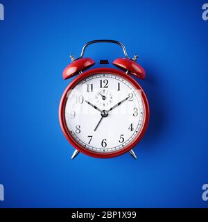 Orologio classico rosso da tavolo su sfondo blu. illustrazione del rendering 3d Foto Stock