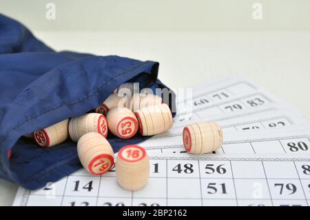 Barili di legno lotti un sacchetto e le carte per giocare lotto sul tavolo. Foto Stock