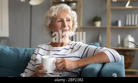 Nonna matura felice bevendo caffè del mattino a casa. Foto Stock