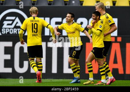 Raphael Guerreiro di Dortmund, centro, tocca i gomiti con Julian Brandt che festeggia dopo aver segnato il suo secondo gol durante la partita di calcio tedesca Bundesliga tra Borussia Dortmund e Schalke 04 a Dortmund, Germania, sabato 16 maggio 2020. La Bundesliga tedesca diventa la prima importante lega di calcio al mondo a riprendere dopo due mesi di sospensione a causa della pandemia del coronavirus. Foto Stock