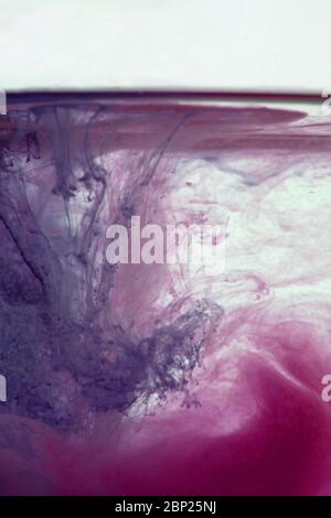 una bella immagine di un liquido colorato rosa e viola che si mescola in acqua, modello astratto Foto Stock
