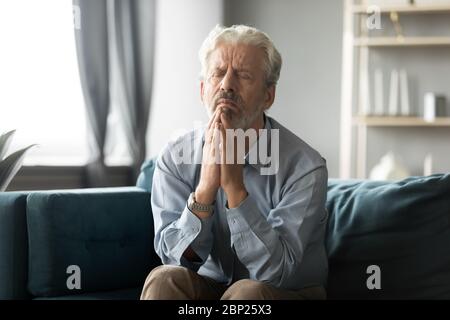 Fedele anziano di mezza età che prega Dio. Foto Stock