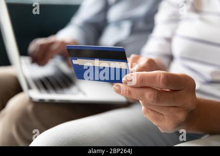 Primo piano donna anziana in pensione che tiene in mano la carta bancaria. Foto Stock