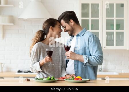 Coppia millenaria amorosa che ha data romantica in cucina insieme Foto Stock