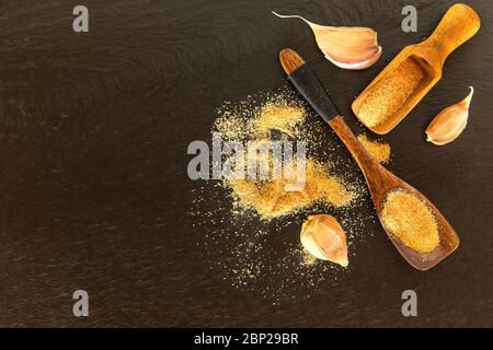 Un mucchio di sale di aglio selvatico essiccato su una piastra di ardesia. Cibo piccante. Spezie calde. Foto Stock