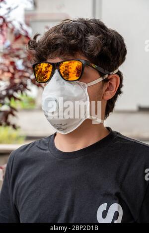 ragazzo con maschera viso anti coronavirus protezione e occhiali da sole Foto Stock