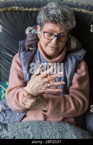 Senior donna che soffre di un dolore articolare in mano. Foto Stock