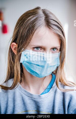 Ragazza di 12 anni che indossa una maschera protettiva durante la pandemia di Covid 19. Foto Stock