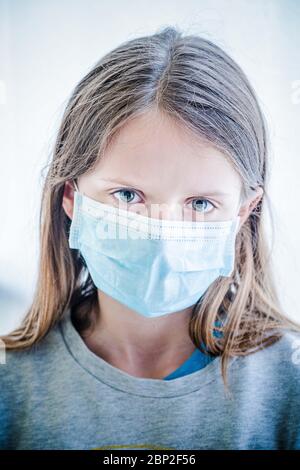 Ragazza di 12 anni che indossa una maschera protettiva durante la pandemia di Covid 19. Foto Stock