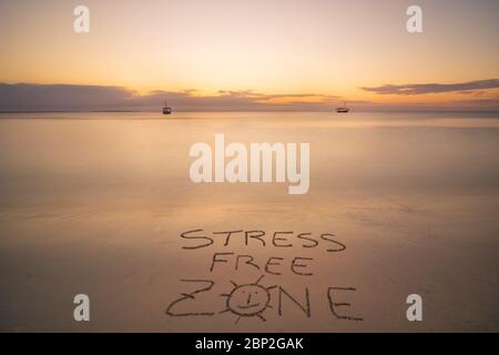 Zona senza stress scritta a mano sulla spiaggia di sabbia al tramonto, relax e concetto estivo, spiaggia repubblica Dominicana. Foto Stock