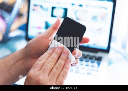 Pulizia dello schermo del telefono cellulare con salviette bagnate disinfettanti per smartphone pulizia pulizia preventiva per COVID-19 protezione da focolai di Coronavirus Foto Stock