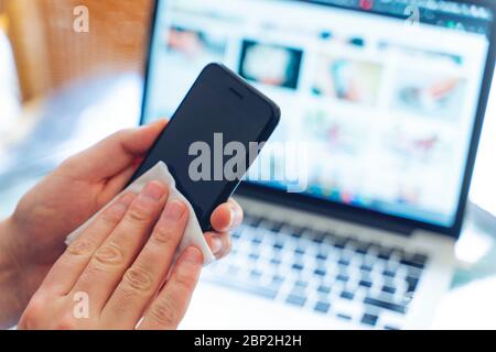 Pulizia dello schermo del telefono cellulare con salviette bagnate disinfettanti per smartphone pulizia pulizia preventiva per COVID-19 protezione da focolai di Coronavirus Foto Stock