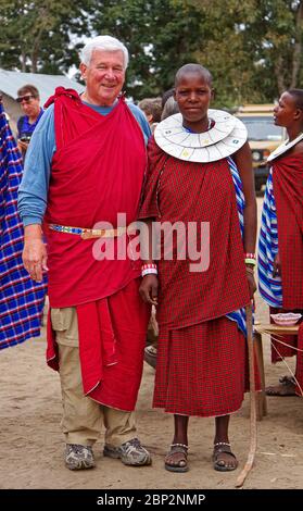 Villaggio Maasai, uomo in visita, donna indigena; abito tradizionale, colletto a 2 strati con perline, apprendimento, istruzione, Tanzania; Africa, MR Foto Stock