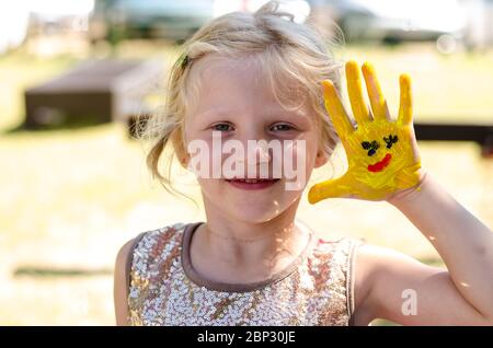 bambino felice con immagine colorata dipinta sulla sua mano e le dita Foto Stock