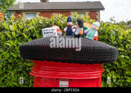 Personaggi a maglia che rappresentano i lavoratori chiave in cima a una casella postale nel villaggio di West End, Surrey, Regno Unito, durante la pandemia del 2020 coronavirus covid-19 Foto Stock