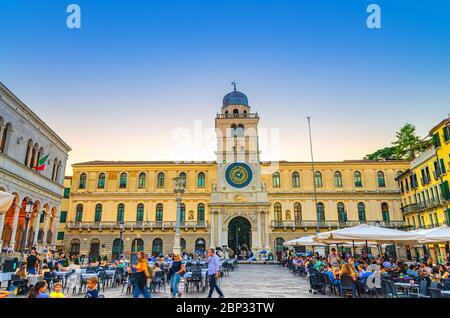 Padova, 12 settembre 2019: Torre dell'Orologio con orologio astronomico e tavoli da ristorante in Piazza Plaza dei Signori, vista serale al crepuscolo, Regione Veneto Foto Stock