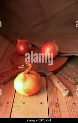 Cipolla e fette su tagliere di legno. Cipolle al tavolo di legno Foto Stock