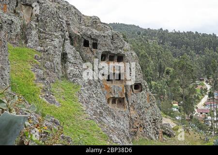 Cripte tagliate nella scogliera di fronte Otuzco sito archeologico, vicino Cajamarca, Perù marzo Foto Stock