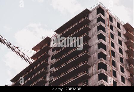 Primo piano, foto d'arte di un cantiere e di una gru che costruisce un grattacielo Foto Stock