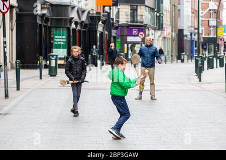 La famiglia gioca a fare un'esultante sulla deserta Grafton Street nel centro di Dublino, mentre le aziende e i negozi rimangono chiusi e i calci piovono a causa del Covid-19. Foto Stock