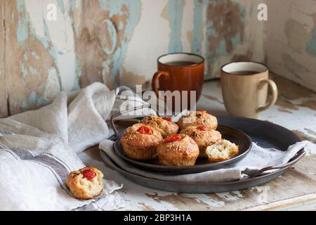 Muffin con formaggio, formaggio di campagna e pomodori, serviti con tè. Foto Stock