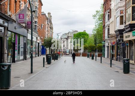 I pedoni passeggiano attraverso una strada deserta Grafton nel centro di Dublino, mentre i negozi rimangono chiusi a causa di restrizioni pandemiche di coronavirus. Foto Stock