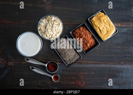 Cioccolato farina d'avena ingredienti: Avena arrotolata, semi di chia e altri ingredienti frullati per la colazione Foto Stock