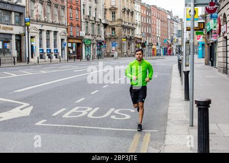 L'uomo scherza sulla strada deserta Dame nel centro di Dublino. Traffico ridotto a causa delle restrizioni pandemiche di Coronavirus. Maggio 2020, Dublino, Irlanda Foto Stock