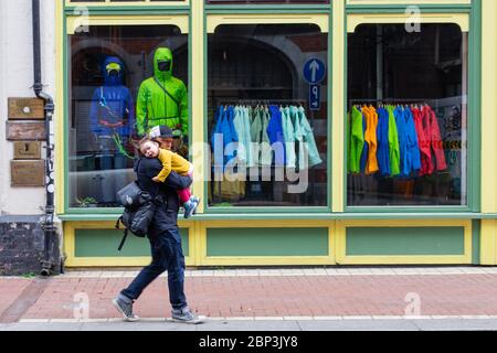 Padre che porta la figlia in braccio passa presso un negozio all'aperto a Wicklow Street a Dublino, Irlanda. Foto Stock