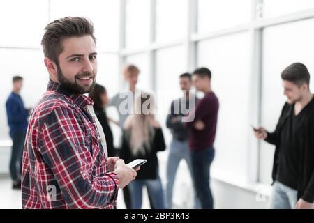 giovane e pusivo in piedi nella lobby dell'ufficio Foto Stock