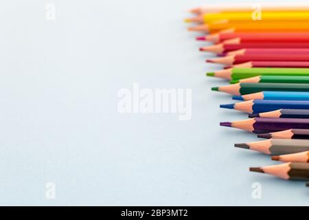 una serie di matite colorate allineate da scure a chiare, che si concentrano in primo piano Foto Stock