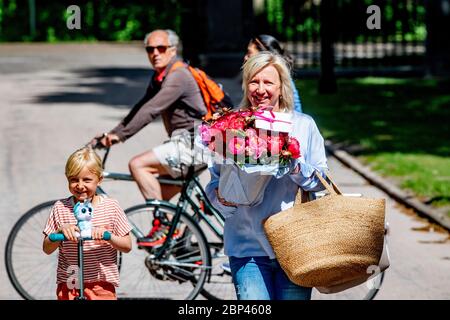 Ellen Joosten seguito da un bambino porta i fiori al Paleis Huis Ten Bosch per il 49° compleanno della regina Maxima. Foto Stock