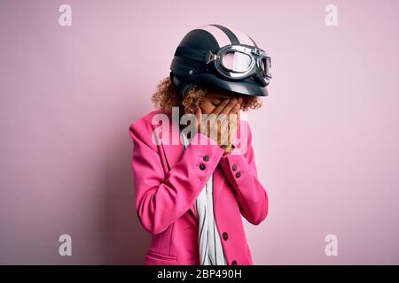 Bella motociclista donna con capelli ricci che indossa casco moto su sfondo  bianco guardando a lato, profilo relax posa con viso naturale con conf Foto  stock - Alamy