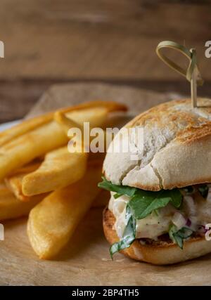 Insalata di gamberi su involtino di hoagie con rucola e patate fritte in forno in casa. Foto Stock