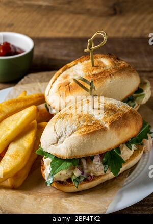 Insalata di gamberi su involtino di hoagie con rucola e patate fritte in forno in casa. Foto Stock