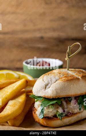 Insalata di gamberi su involtino di hoagie con rucola e patate fritte in forno in casa. Foto Stock