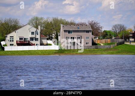 Carol Stream, Illinois, Stati Uniti. Piogge pesanti dalla notte prima di riempire un stagno di ritenzione un encoach su cantieri residenziali. Foto Stock