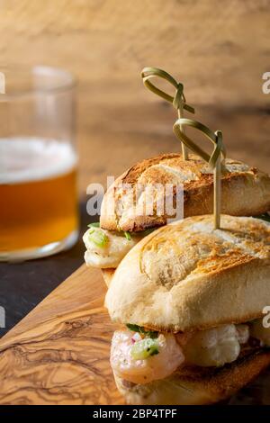 Insalata di gamberi su involtino di hoagie con rucola e patate fritte in forno in casa. Foto Stock