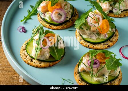 Insalata di gamberi su cracker interi di grano sul piatto di servizio della festa. Foto Stock