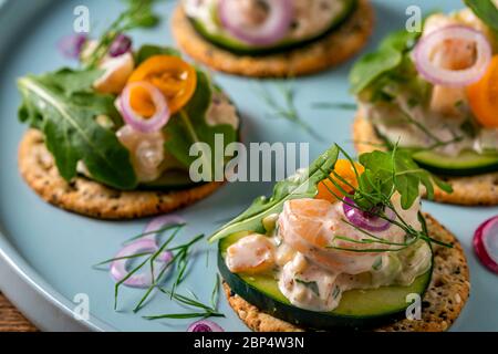 Insalata di gamberi su cracker interi di grano sul piatto di servizio della festa. Foto Stock