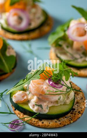 Insalata di gamberi su cracker interi di grano sul piatto di servizio della festa. Foto Stock