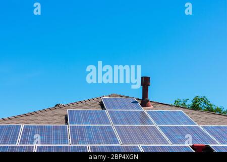 Dettagli di pannelli solari installati sul tetto di una singola casa residenziale famiglia sotto cielo blu Foto Stock