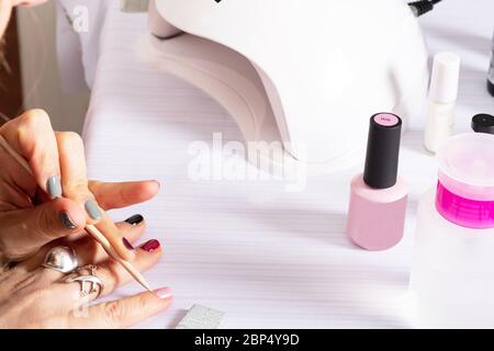 mani di manicure che lavorano con materiali e attrezzi Foto Stock