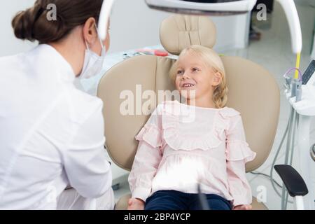 Immagine di bambina con denti controllati dal medico in una Foto Stock