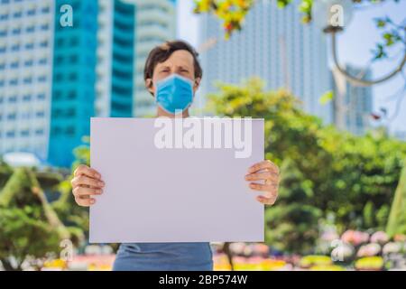 L'uomo in maschera medica previene la malattia del coronavirus tiene un manifesto per le iscrizioni gratuite. SPAZIO DI COPIA Foto Stock