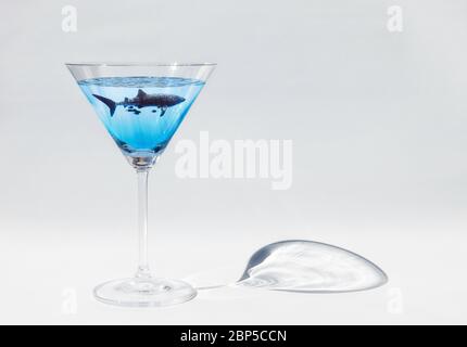 Sharktini: Profilo dello squalo balena (Rhincodon typus) nuoto con i martini neri (Caranx lugubris) in un bicchiere martini su sfondo bianco, Oceano Pacifico Foto Stock